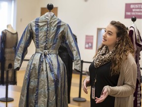 Nicole Chittle, research assistant and curator of the Bustles and Bows exhibit on women's fashions from the Victorian Era to the 1920s, shows off one of the dresses on display at the Chmczuck Museum, Saturday, Feb. 15, 2020.