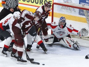Peterborough Petes' Michael Little is checked off a loose puck by Windsor Spitfires' Ruben Rafkin next to goalie Kari Piiroinen during first period OHL action on Thursday February 13, 2020 at the Memorial Centre in Peterborough, Ont.