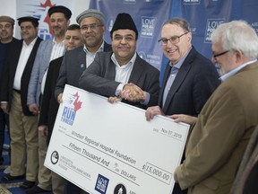 Nasir Ahmed, left, National vice-president of the Ahmadiyya Elders Association, shakes hands with John Comisso, president of the Windsor Regional Hospital Foundation, as he receives a cheque for $15,00 from the Ahmadiyya Muslim Jama'at's Run for Windsor on Feb. 21, 2020.