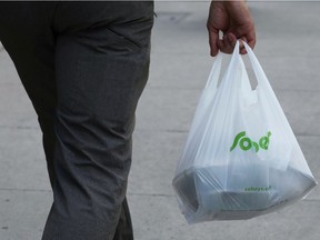 A customer leaves a Sobeys grocery store carrying a plastic bag in Ottawa, Ontario, Canada, July 31, 2019.