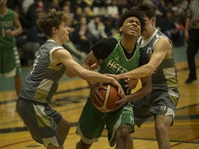 WINDSOR, ONT:. FEBRUARY 23, 2020 -- Herman's Desmond Price gets tied up by Riverside's Noah Borg, left, and Quinn Carey, during the WECSSAA boys basketball AA final between the Herman Green Griffins and the Riverside Rebels at the SportsPlex, Sunday, Feb. 23, 2020.