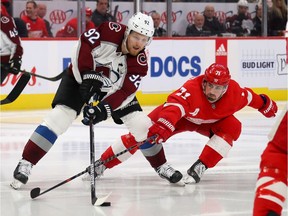 Gabriel Landeskog of the Colorado Avalanche tries to get around the stick of Dylan Larkin of the Detroit Red Wings during the third period at Little Caesars Arena on March 02, 2020 in Detroit, Michigan. Colorado won the game 2-1.