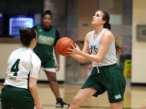 St. Clair College Saints Nicole Tamm, right, drives to the hoop against teammate Logan Kucera, left, during practice in preparation for the OCAA women's basketball championship tournament at the SportsPlex.