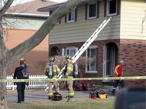 Firefighters and utilities workers attend a fire at 9357 Ryerson Street in Forest Glade Thursday.  The fire caused significant damage to the interior of the semi-detached home.