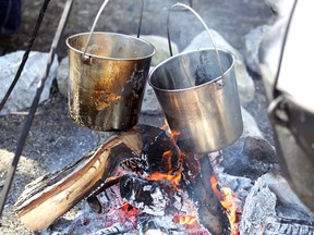 Two pots of maple syrup boil over an open fire during a Maple Syrup Festival demonstration at John R. Park Homestead Saturday, March 7, 2020.