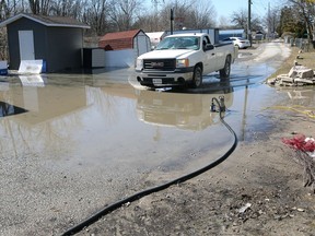 A pickup truck passes through a puddle on Caille Avenue Saturday.  Waves came crashing onshore from Lake St. Clair on Friday, causing flooding of some yards and basements near Belle River.