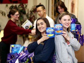 Jada Malott, left, of St. Joseph's Catholic High School and Mira Gillis of F.J. Brennan pose back-to-back during a friendly challenge between Catholic high schools to see which school could donate the most feminine products Tuesday. The official total will be more than 500 products once other schools report their numbers.