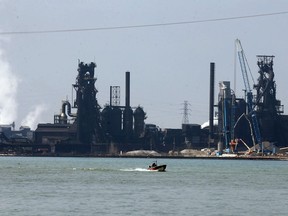 A boater on the Detroit River passes the heavy industrial area known as Zug Island Wednesday.
