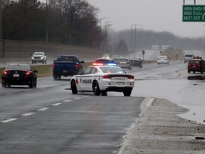Windsor Police direct traffic away from standing water on E.C. Row Expressway, east of Huron Church Road, after heavy rain in March 2020.  Several vehicles were on the side of the road after driving through about 8 cm of water.