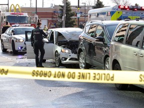 A Windsor police officer examines the scene of a four-vehicle collision at Ouellette Avenue and Wyandotte Street on the morning of March 29, 2020.