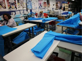Employees at Brian Custom Sports sew protective gowns for healthcare workers.      Image courtesy of Joe Aitken / Windsor Star