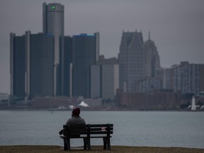 Matthew Woodford sits on a bench overlooking the Detroit skyline in Detroit on March 24, 2020.