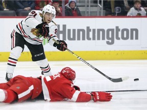 Chicago Blackhawks centre Drake Caggiula (91) passes the puck against Detroit Red Wings defenseman Filip Hronek (17) during the first period of an NHL hockey game Friday, March 6, 2020, in Detroit.