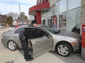 A Windsor Police officer investigates the scene of an accident on Thursday, March 5, 2020, at the Shoppers Drug Mart at Lauzon and Wyandotte St. E in Windsor. The driver of a car smashed into the store causing damage to a large window. No injuries were reported.