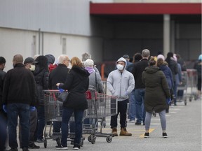 WINDSOR, ONT:. MARCH 24, 2020 -- Long lines form outside Costco on Walker Road as the store limits the number of shoppers inside the store, Tuesday, March 24, 2020, as the COVID-19 pandemic continues.