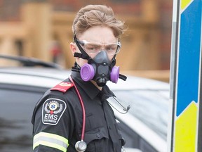 An Essex-Windsor EMS member dons personal protective equipment before handling a patient on March 20, 2020.
