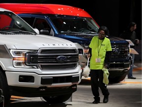 FILE PHOTO: FORD MOTOR: A worker dusts a Ford F150 Limited pickup truck at the North American International Auto Show in Detroit, Michigan, U.S., January 15, 2019.