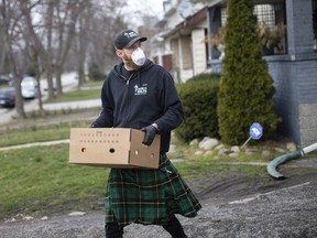 Helping the vulnerable. Ben Snow, owner of Men in Kilts Windsor, is shown Friday, March 27, 2020, delivering groceries to a home on Campbell Avenue as the COVID-19 pandemic continues to keep people isolated in their homes.