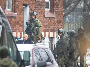 Windsor police and Essex County OPP officers at the scene of a standoff with a man inside a residence in the area of McKay Avenue and Rooney Street on March 23, 2020.