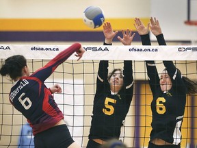 KINGSVILLE, ON. MARCH 11, 2020 -Carlie Pappano, left, of Widdifield Secondary spikes into the block of Brynlee Ammonite, centre, and Lexi Dodds of General Amherst during the OFSAA bronze medal game in Kingsville, ON. on Wednesday, March 11, 2020.