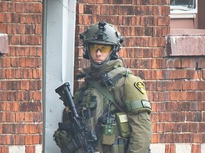 A geared-up member of the Essex County OPP Emergency Response Team (ERT) keeps watch at the scene of a standoff in Windsor on March 23, 2020.