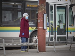 A woman waits to board a Transit Windsor bus at the downtown Windsor International Transit Terminal on March 20, 2020. Transit Windsor is reducing schedules, closing the downtown terminal, and implementing other new protocols as the COVID-19 pandemic continues.