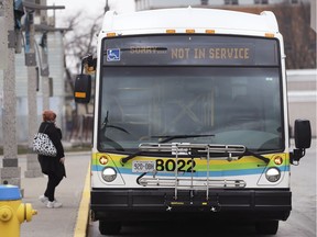 "Not in Service." A woman is shown near a Transit Windsor bus at the downtown terminal in Windsor on Thursday, March 26, 2020.