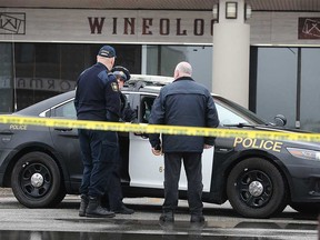 OPP officers and fire investigators confer at Wineology in Green Valley Plaza in Tecumseh after a fire on March 2, 2020. The Ontario Fire Marshal's office has determined that the incident was a case of arson.