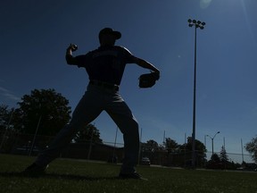 Tecumseh Thunder player Derrick Fortier warms up in the outfield in front of a new light pole during the unveiling of the $500,000 worth of renovations to the Lacasse Park baseball diamond in Tecumseh on June 5, 2013.