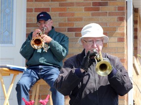 Musicians Kevin Masterson, front, and Dave Willick, play during an encore performance for their South Windsor neighbourhood Saturday. With rain in the forecast, Willick raised the curtain early on his first, front porch show, then added a second show as skies cleared at 1p.m.