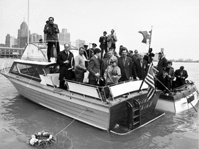 Mourning a death. Autoworkers on boats from both sides of the border, including members of the United Auto Workers' Downriver Anti-Pollution League, hold a wake on the Detroit River on the first Earth Day, April 22, 1970, and lay a floral wreath to signify the "death" by pollution of the river and Lake Erie.