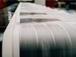Newspapers being printed on rolls of paper