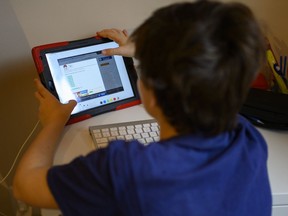 Colin, 10 years old, whose school was closed following the Coronavirus outbreak, does school exercises at home in Washington on March 20, 2020. - As millions of families hunker down amid the coronavirus crisis, the sudden reality of schooling from home risks widening the education gap between those with the means and support to keep up with lessons, and those who risk falling behind.