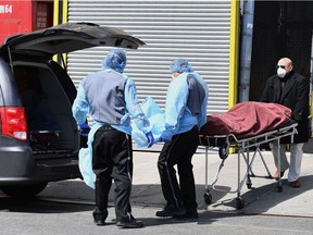 A body is picked up from the Wyckoff Heights Medical Center on April 2, 2020 in Brooklyn, New York. - The Federal Emergency Management Agency (FEMA) has asked the US Defense Department for 100,000 body bags as the toll mounts from the novel coronavirus, the Pentagon said on April 2. White House experts have said that US deaths from the disease -- currently at more than 5,100 -- are expected to climb to between 100,000 and 240,000, even with mitigation efforts in force.