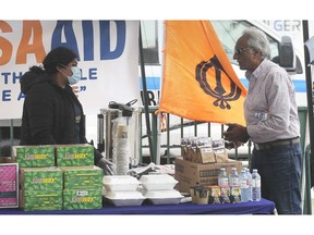 TECUMSEH, ON. APRIL 29, 2020 -  The Khalsa Aid Windsor team handed out free meals to truck drivers on Thursday, April 30, 2020, at the Ambassador Duty Free store in Windsor, ON. April is Sikh Heritage Month and the initiative was part of the celebration. Neha Kaur, left, speaks to a truck driver during the event.