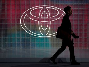 FILE PHOTO: A man walks past a Toyota logo at the Tokyo Motor Show, in Tokyo, Japan October 24, 2019.