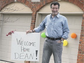 Dr. Dean Favot holds a welcome-home sign outside his house on Sunday, April 26, 2020. A day earlier he had returned to cheers, following a stay in the ICU unit of the hospital due to COVID-19.
