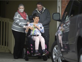Parents, Marleen and Ian Crawford, are pictured with their daughter, Megan Crawford, 45, outside her home, Monday, April 13, 2020.