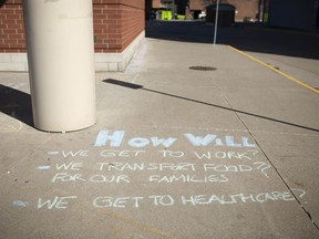"How will we ..." Messages written in chalk protesting the mayor's decision to shut down Transit Windsor service, are shown on the pavement surrounding the downtown bus terminal, Monday, April 6, 2020.