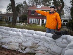 Don Wilson, a power of attorney for an elderly woman who lives on Riverside Drive East, and whose Windsor property was being threatened by flooding, stands behind a wall of sandbags on April 16, 2020.