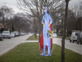 A frontline medical worker, donning a cape, is sketched onto cardboard and erected on the Kildare Road boulevard outside Windsor Regional Hospital - Met Campus, Tuesday, March 31, 2020, as our healthcare workers begin battle against COVID-19. Windsor illustrator George Rizok made the sign.