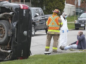 WINDSOR, ON. APRIL 25, 2020 -  The 1700 block of Hickory Rd. was shut down to traffic on Saturday, April 25, 2020, as emergency personnel dealt with a roll-over accident. A man sustained minor injuries after rolling his truck. Two parked cars were damaged. A firefighter and paramedic are shown with the driver.