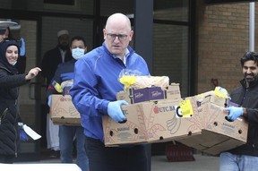 Windsor Mayor Drew Dilkens carries a load of food during the April 10 launch of a volunteer food hamper delivery service organized by the Windsor Islamic Association.