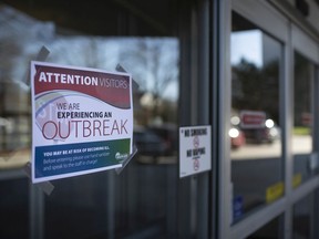 Signs warning the public of an outbreak situation at Windsor retirement home Lifetimes On Riverside, photographed April 2, 2020.