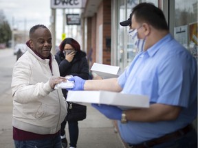 Khassan Saka, founder of the Windsor-based Iraqi Canadian Group Organization, hands out masks to the public at the ICGO office at 397 Wyandotte St. W. on April 14, 2020.