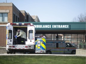 An EMS paramedic cleans his ambulance outside of Windsor Regional Hospital - Met Campus, as the COVID-19 pandemic continues, Thursday, April 2, 2020.