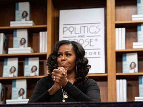 In this file photo former U.S. first lady Michelle Obama meets with fans during a book signing on the first anniversary of the launch of her memoir "Becoming" at the Politics and Prose bookstore in Washington, D.C., on Nov. 18, 2019.