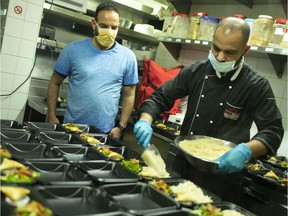 Eastern Flavours co-owner, Ahmed Zabian, left, watches on April 28, 2020, as head chef, Khalid Baig, portions out white rice to meals being distributed by the Windsor Islamic Association during Ramadan.