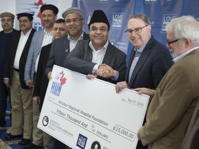 Nasir Ahmed, left, national vice-president of the Ahmadiyya Elders Association, shakes hands with John Comisso, president of the Windsor Regional Hospital Foundation, as he receives a cheque for $15,000 on Feb. 21, 2020, proceeds from last year's Ahmadiyya Muslim Jama'at's Run for Windsor.