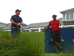 Phil Mickelson and Tiger Woods wait to play from the tenth tee during The Match: Champions For Charity at Medalist Golf Club on Sunday.